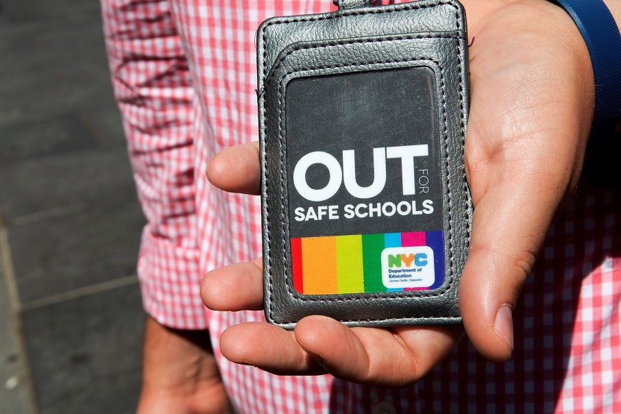 A person holds out a wallet showing an ID card that reads A person holds out a wallet showing an ID card that reads