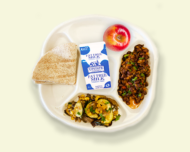 BigCityTaco Plate of school food with low fat milk, stewed beans, zucchini with corn, an apple, and a whole wheat tortilla